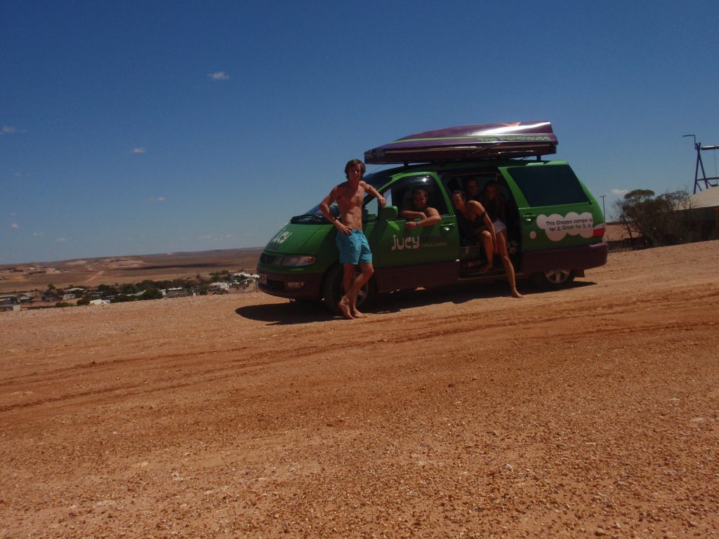 David Simpson and the gang with the green rental car during road trip in the middle of the desert in Australia. Rescued in the middle of the desert