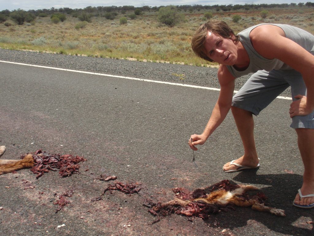 David Simpson with roadkill during the road trip in the middle of the desert in Australia. Rescued in the middle of the desert