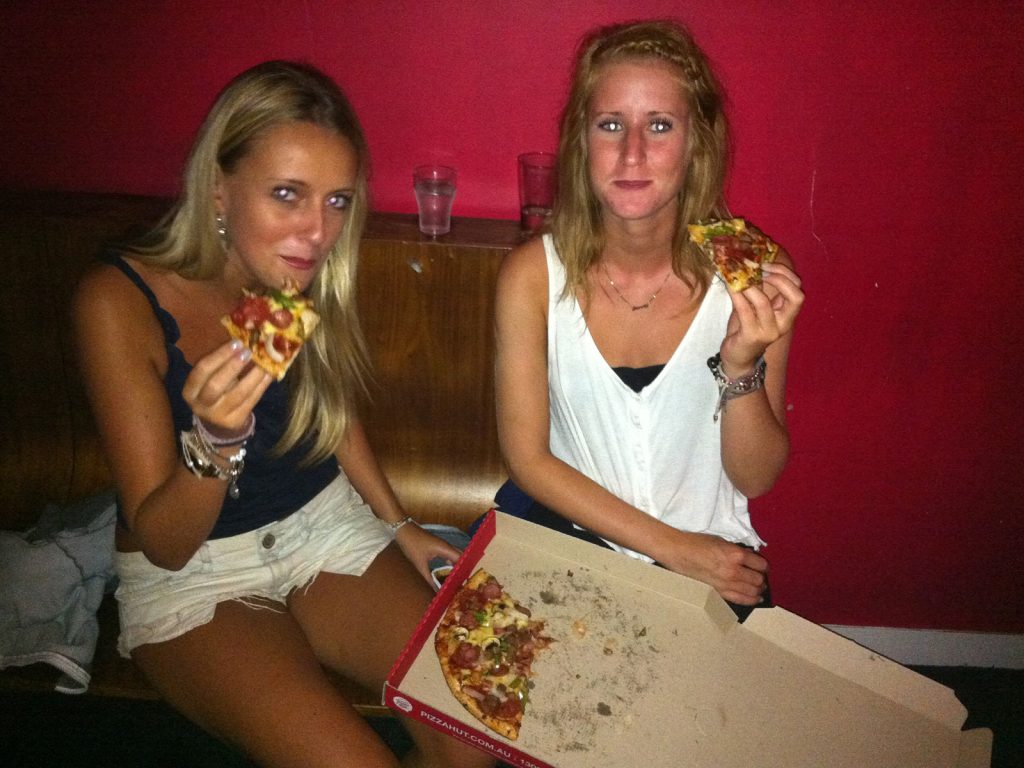Two girls eating pizza in Australia. Rescued in the middle of the desert