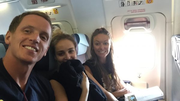 David Simpson with two girls onboard a plane to India. India, a unique experience