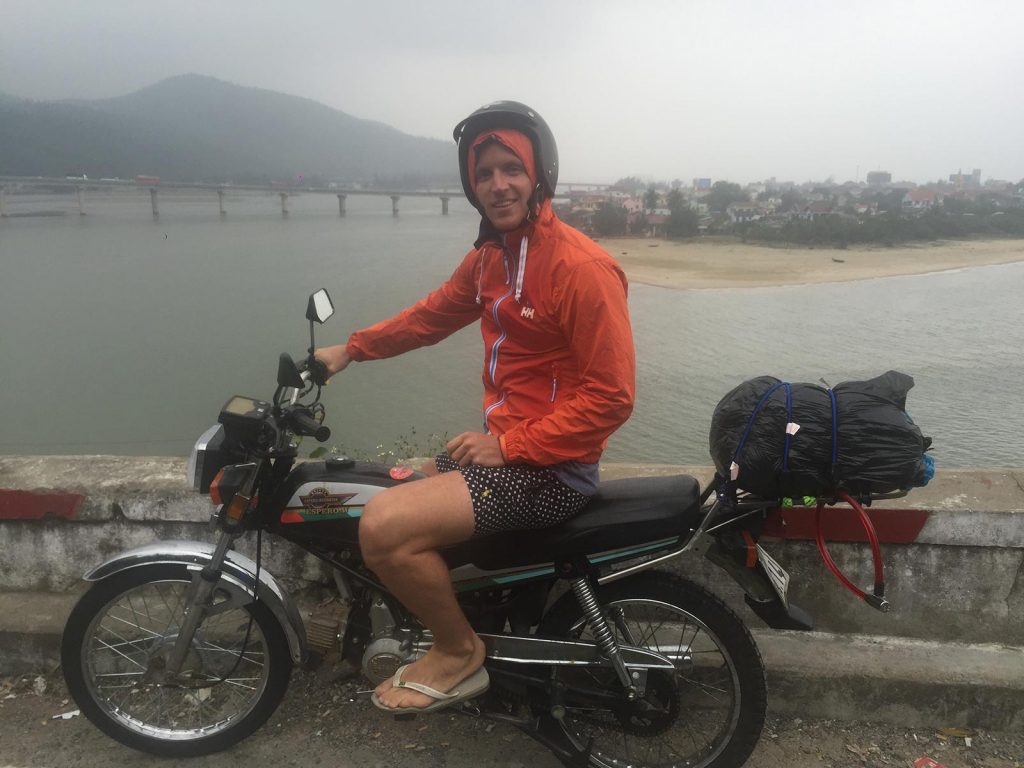 David Simpson on a motorbike near a river in Hoi An, Vietnam. Hoi Van Pass, Hoi An & a poor man's bag