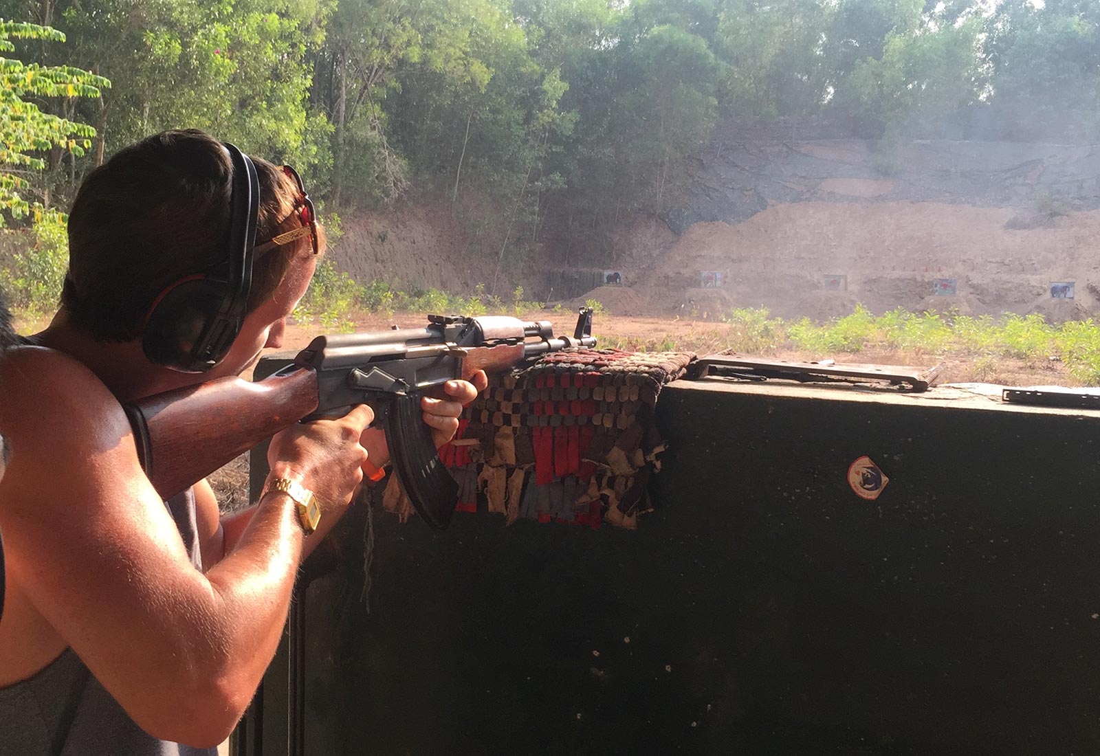 David Simpson shooting a rifle at a shooting range in Ho Chi Minh, Vietnam. Stabbings & tunnels in Ho Chi Minh