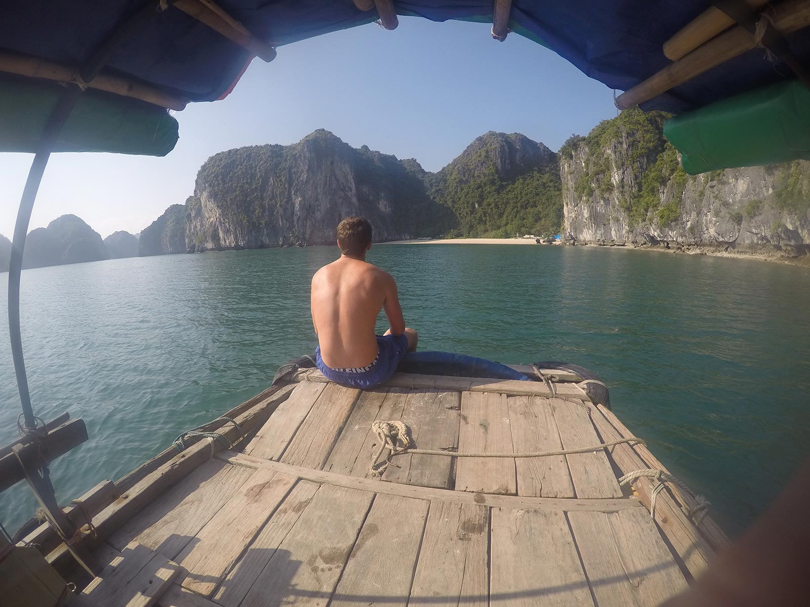 David Simpson on a boat looking at the towering limestone islands in Ha Long Bay, Vietnam. Rock climbing in Ha Long Bay