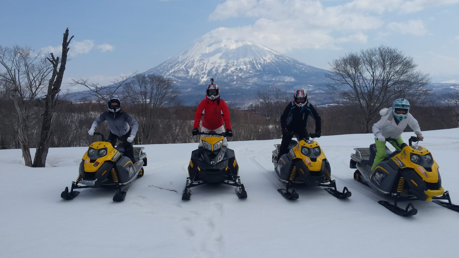 Riding snowmobile with the family with Mount Yotei backdrop in Niseko, Japan. Skiing & Snowmobiles in Niseko, Japan