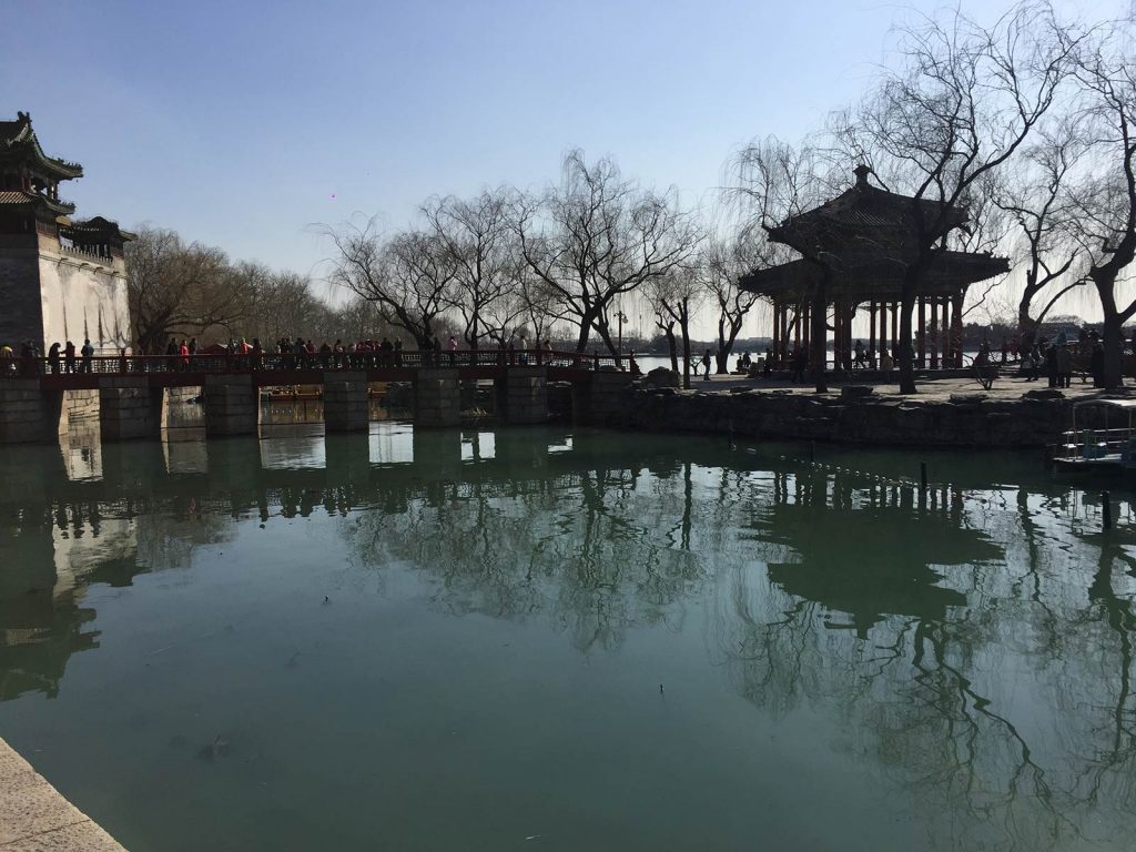 A lake with a bridge full of tourists at the Summer Palace in Beijing, China. The Summer Palace