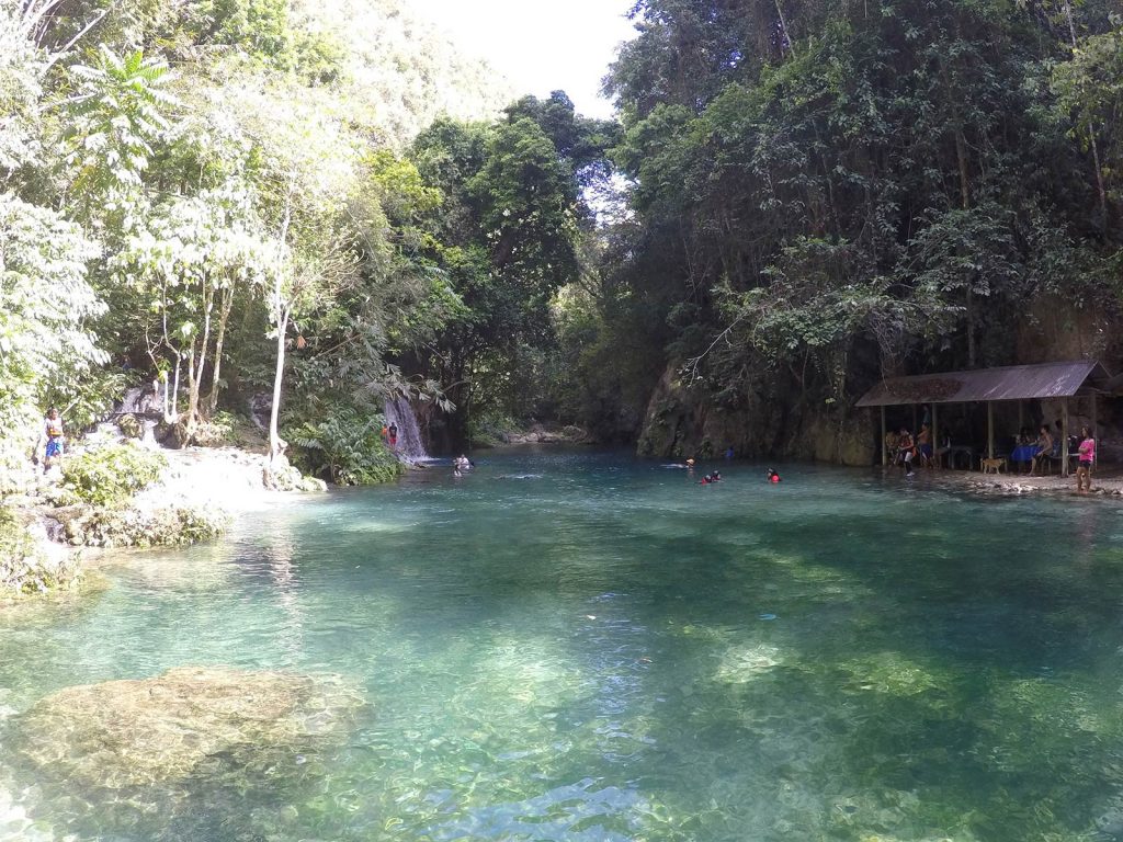 A small waterfall by the river surrounded by trees in Moalboal, Philippines. Canyoneering in Moalboal