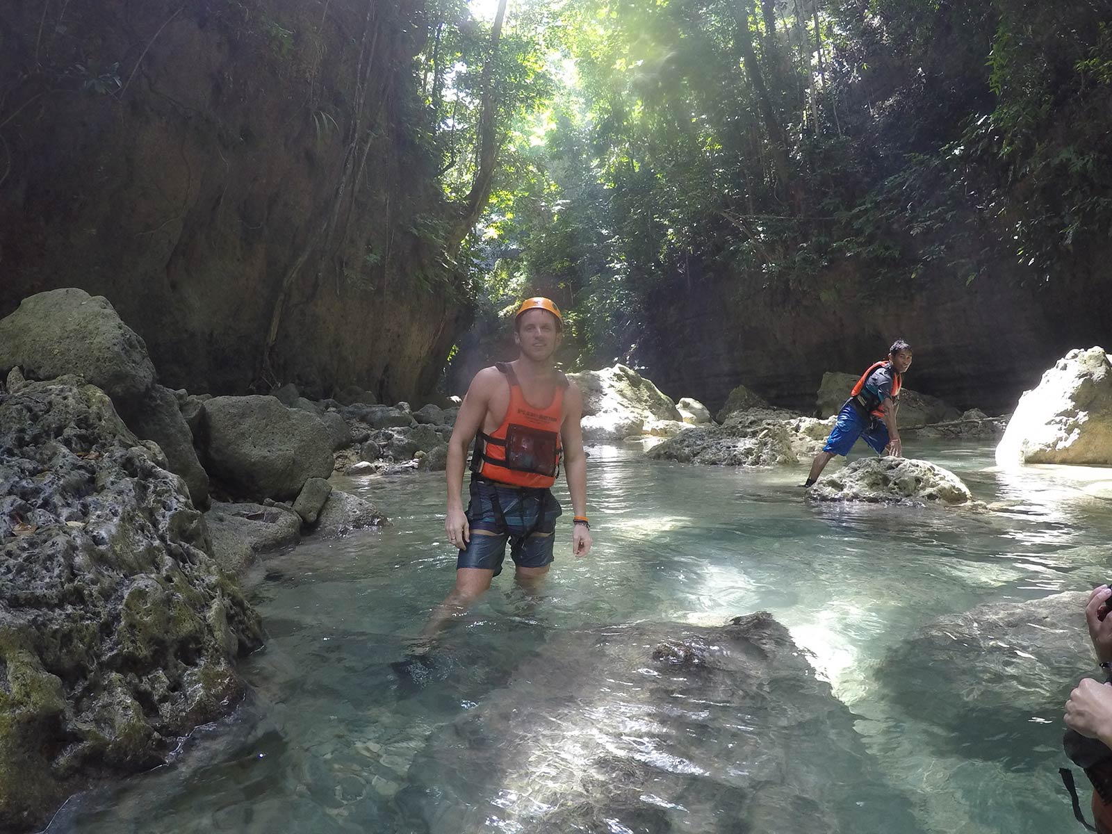 David Simpson at the rocky river surrounded by trees in Moalboal, Philippines. Canyoneering in Moalboal