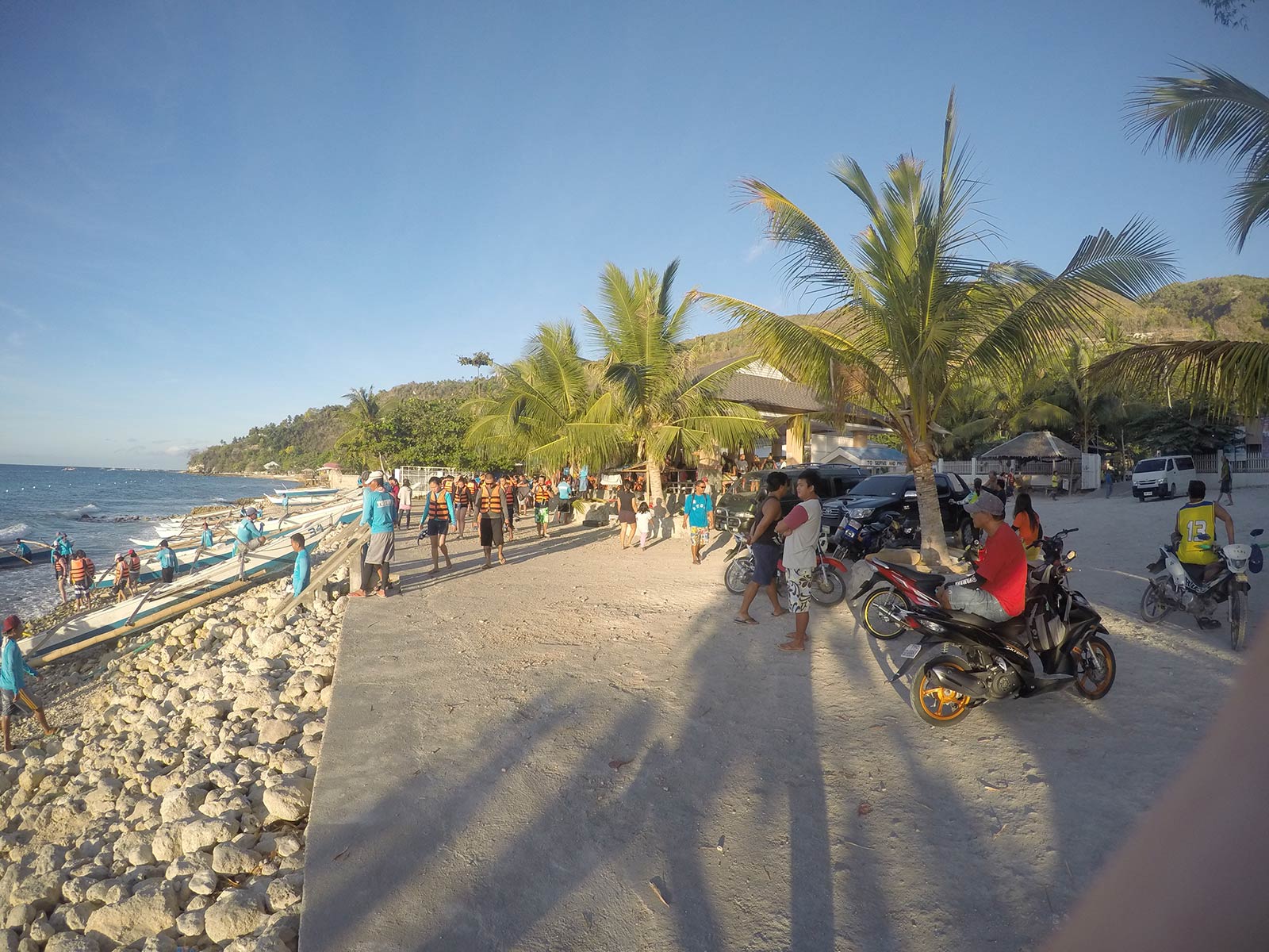 Stony beach with plenty of people in Oslob, Philippines. Regrettably swimming with Whale Sharks