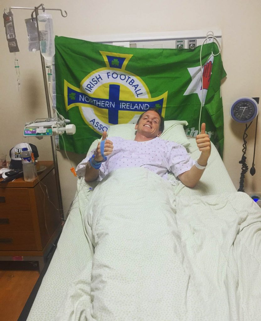 David Simpson lying in bed with NI flag at a hospital in Manila, Philippines. LA Union & hospitalized in Manila