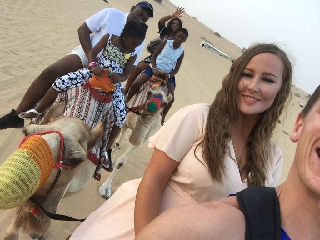 David Simpson and friend girl riding camel at desert in Dubai, UAE. Safaris in Dubai & waffles in Brussels