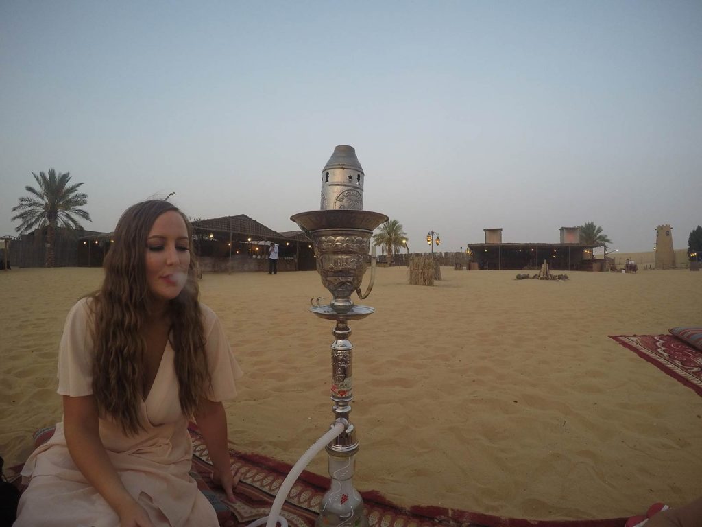 Friend girl smoking shisha at desert in Dubai, UAE. Safaris in Dubai & waffles in Brussels
