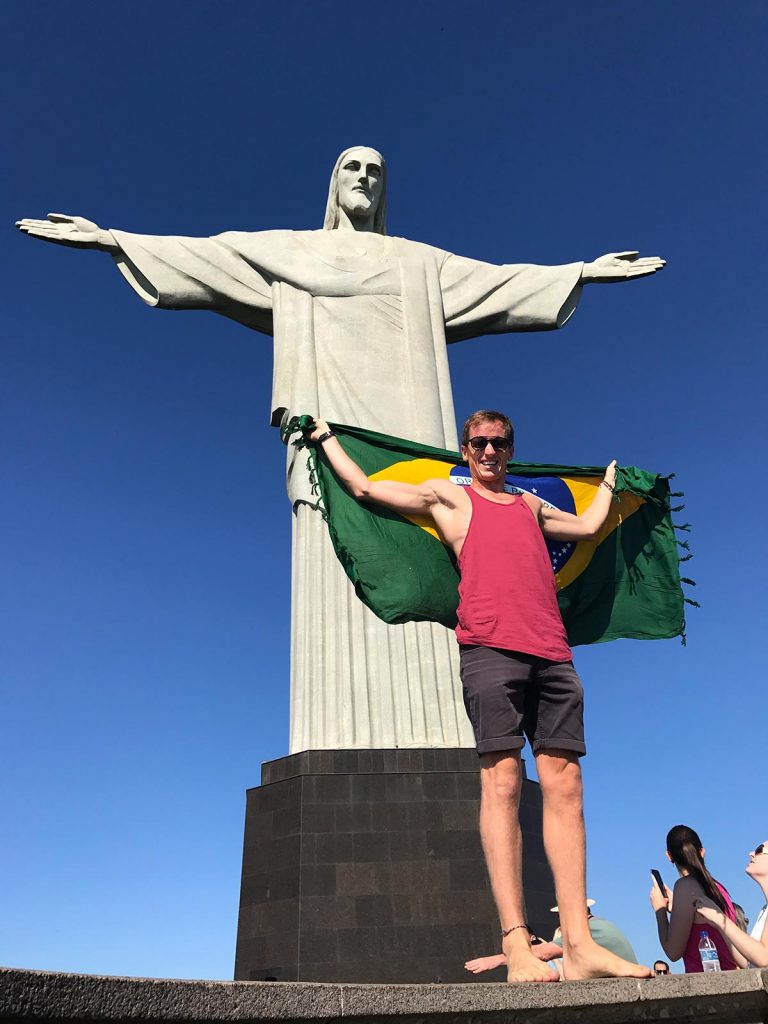 David Simpson holding NI flag at Christ the Redeemer in Rio de Janeiro, Brazil. Friends, steak & Copacabana, a perfect Christmas in Rio