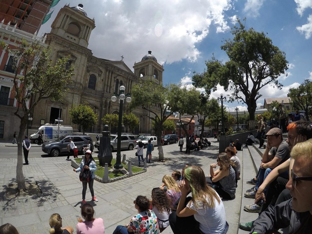 People gathering at the plaza near a church in Bolivia. Cycling Death Road & Full Guide
