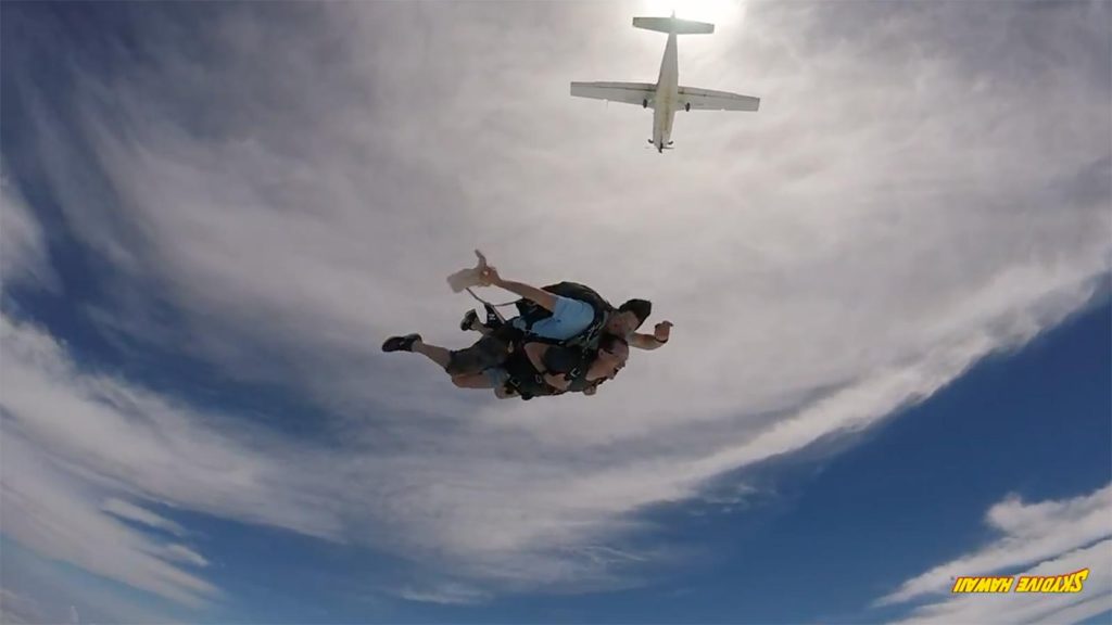 David Simpson jumping off an airplane with instructor in Oahu, Hawaii. Skydiving over Hawaii