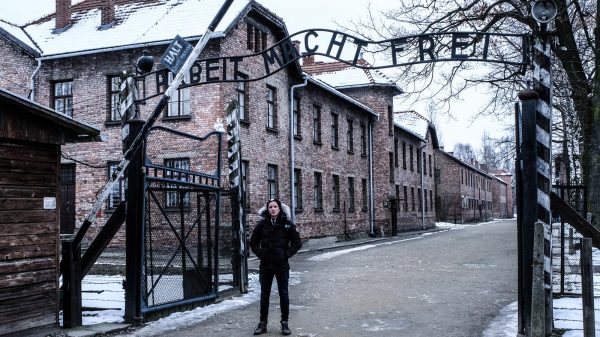 David Simpson at the gate in Auschwitz, Oświęcim, Poland. Full guide & itinerary for Krakow