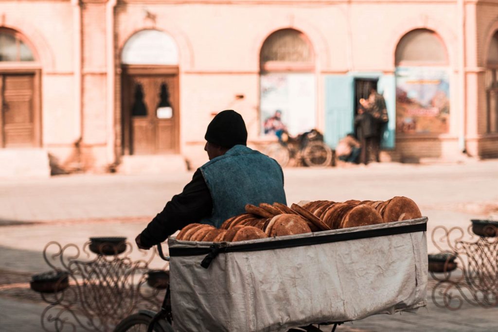 Bread vendor riding a bike in Bukhara, Uzbekistan. A day in Bukhara, the highlight of Uzbekistan