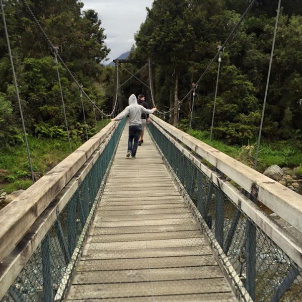Someone walking over bridge in Lake Wanaka, New Zealand. A sprain, football & dodgy DVDs at Lake Wanaka