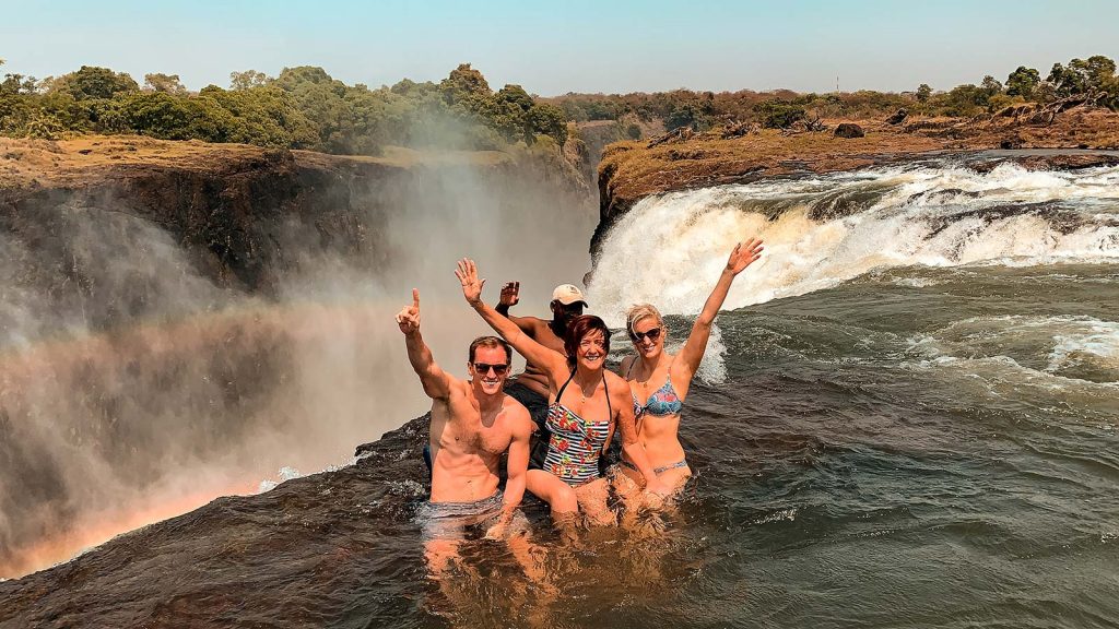 David Simpson and family with a local guy at Devil's Pool at Victoria Falls in Zambia, Africa. The devil's pool