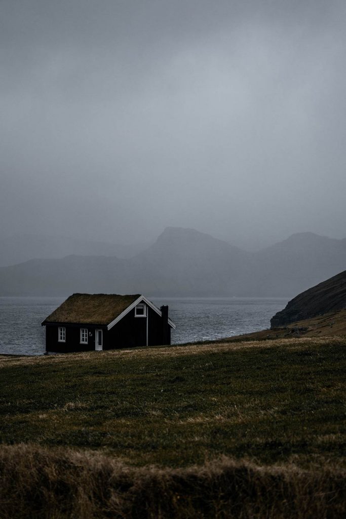 House with turf roof at Gjogv in Faroe Islands. Getting blown off Mt Villingardalsfjall