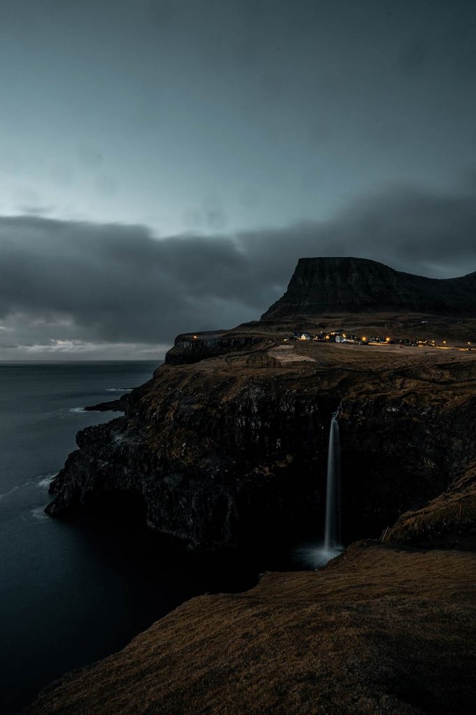 Cliff with waterfalls by the sea at Mulafossa in Faroe Islands. The gem of the Faroe Islands