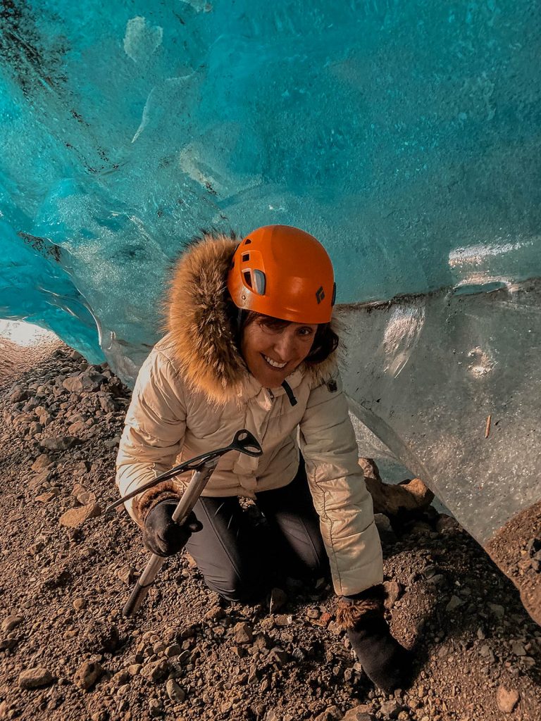 Mom inside ice cave at Skaftafellsjokul glacier in Iceland. Ice caving in Iceland