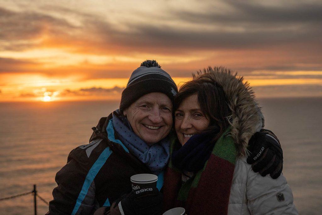 Mom and dad at Reynisfjara black beach during sunset in Iceland. Ice caving in Iceland