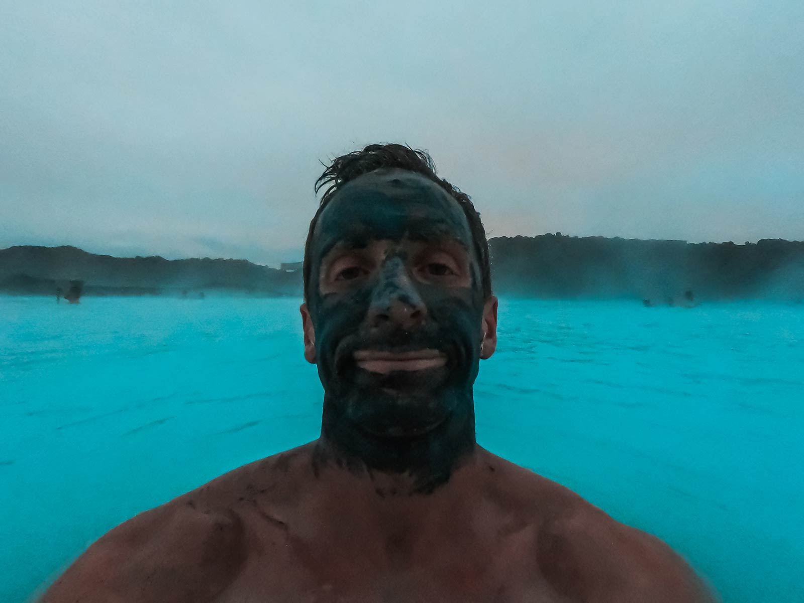 David Simpson with mud mask in Blue Lagoon, Iceland. How to survive layovers