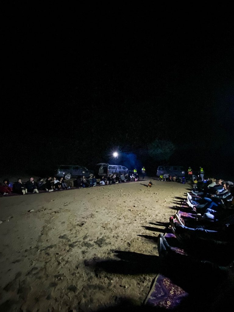 People seated around at night in Saudi Arabia. A trip to the edge of the world