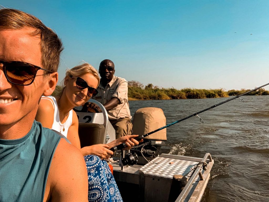David Simpson and sister with local guy fishing at Zambezi River in Namibia, Africa. Kasenu Village, Namibia