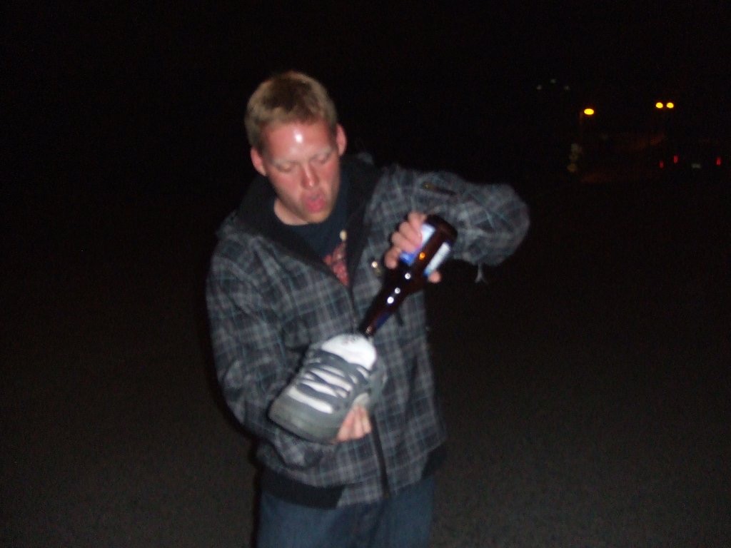 Man pouring beer in shoe in Vancouver. Vancouver to Tofino