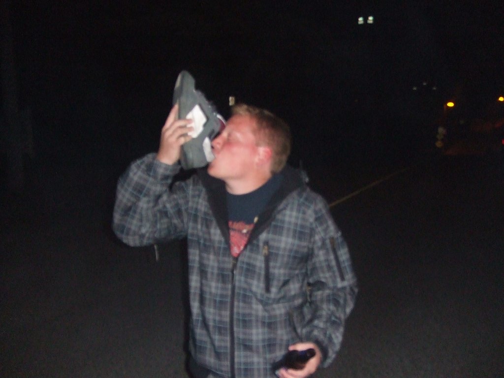 Man drinking from shoe in Vancouver. Vancouver to Tofino