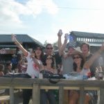 David Simpson with two guys and three girls raising their beer in Calgary. Calgary stampede