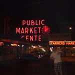 David Simpson and the Public Market Center sign at night in Seattle. Crossing into Seattle