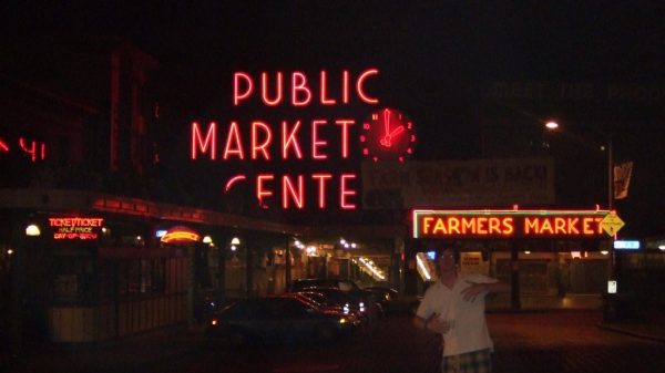 David Simpson and the Public Market Center sign at night in Seattle. Crossing into Seattle