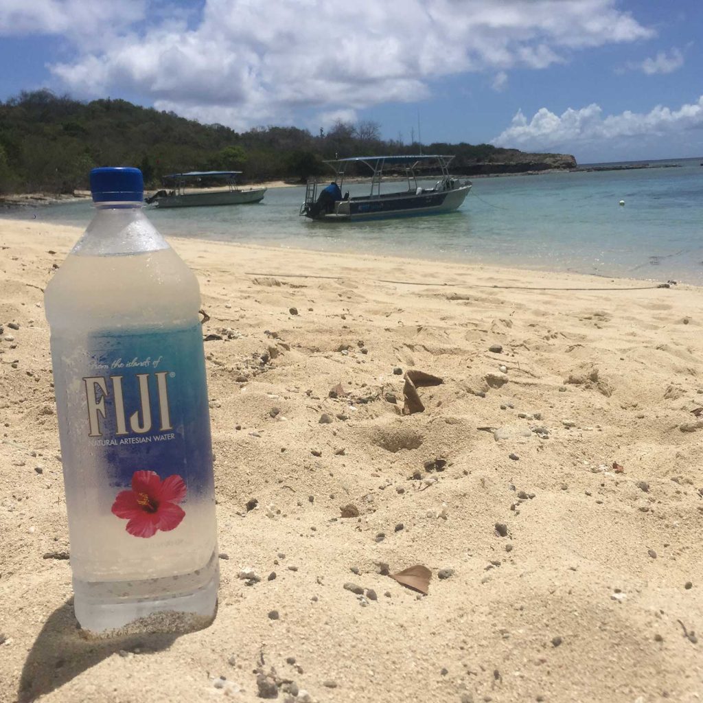 Bottled water on the beach. 5 tips on how to stay healthy while travelling
