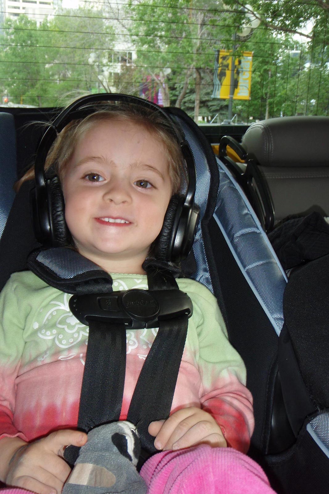 Little girl wearing headphones inside vehicle in Calgary. Cowboys in Calgary