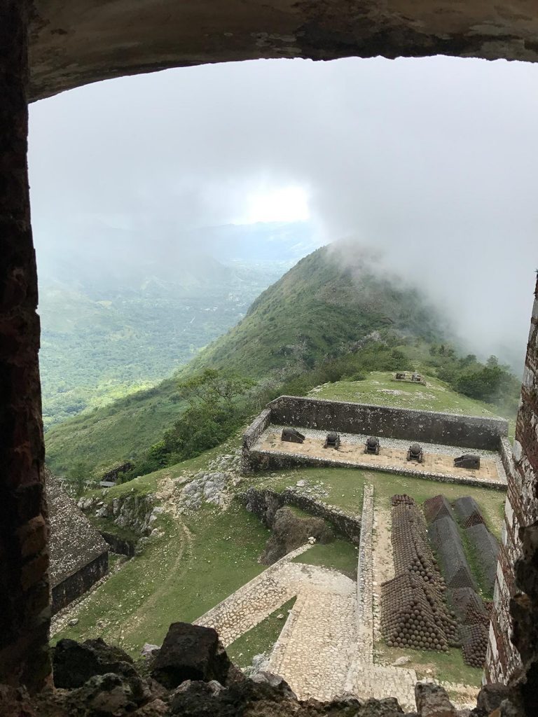 Window view of citadel with cannon and cannonballs below in Haiti. Haiti & Dominican Republic, an Island of two halves