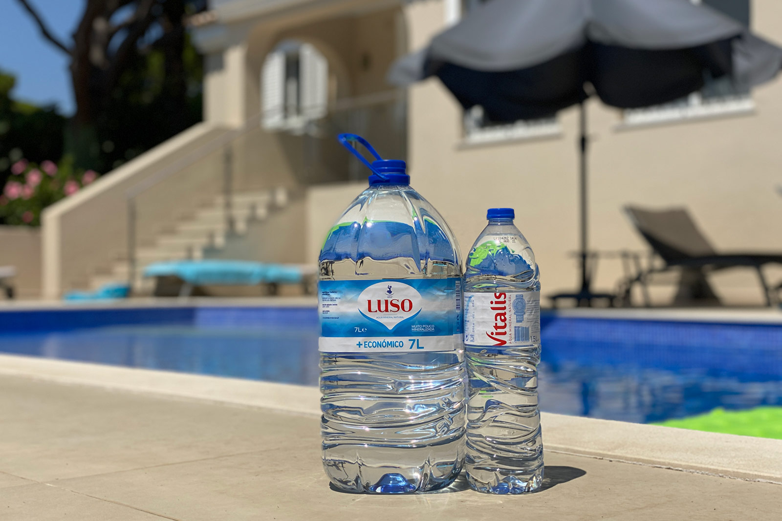 Two large bottles of water sitting next to a pool. Eating healthy while travelling