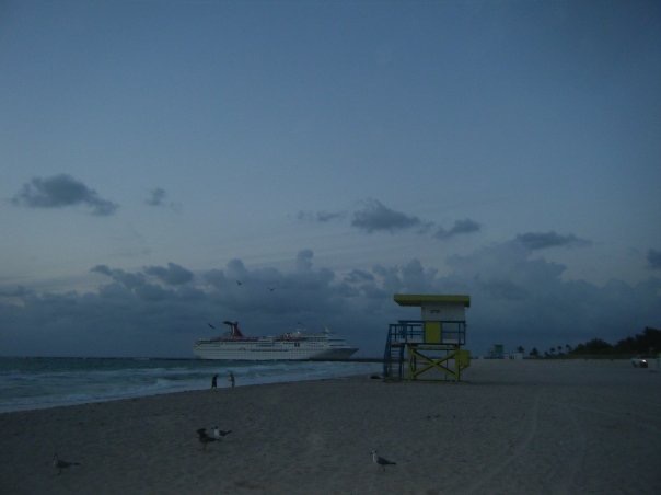 Beach with lifeguard outpost and cruise ship in Miami. Miami's sinking ship