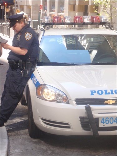 Policeman leaning on a police car in New York. New York, the final stop
