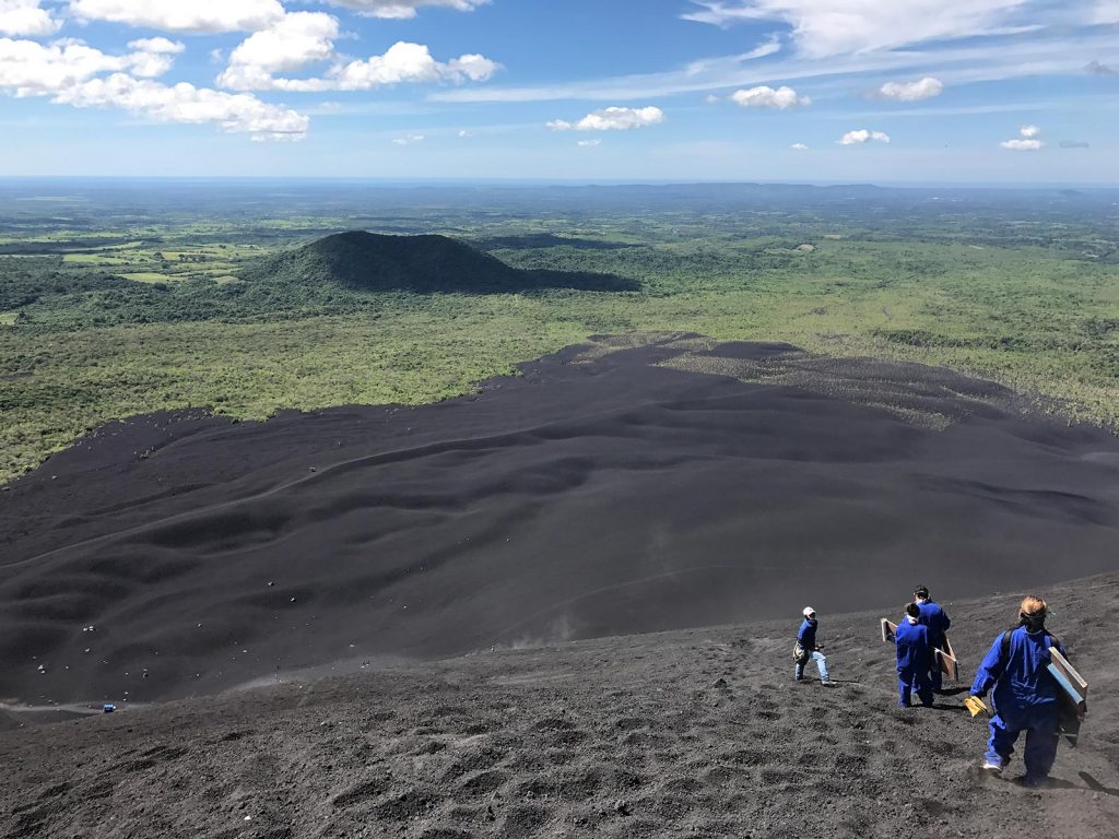 Climbers getting ready to ride their board down the volcano in Leon, Nicaragua. Volcano boarding in Leon, Nicaragua & full guide