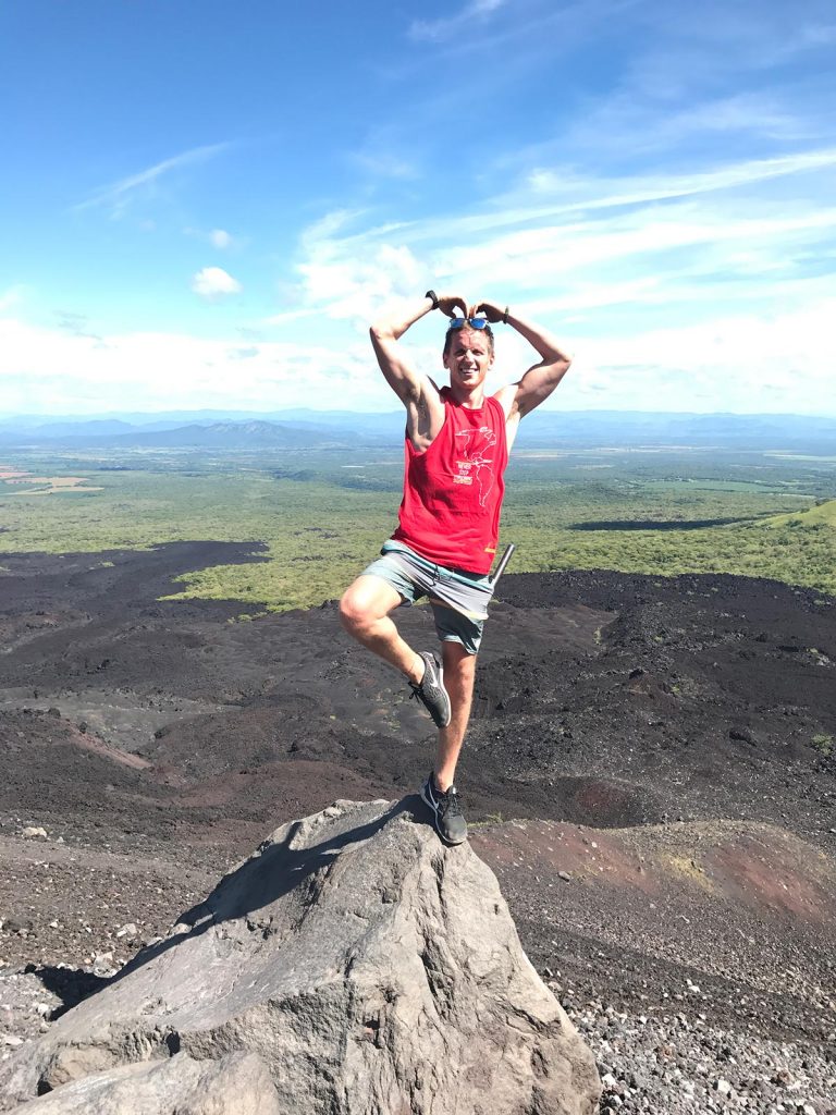 David Simpson standing with one leg on a rock at the top of the volcano in Leon, Nicaragua. Volcano boarding in Leon, Nicaragua & full guide