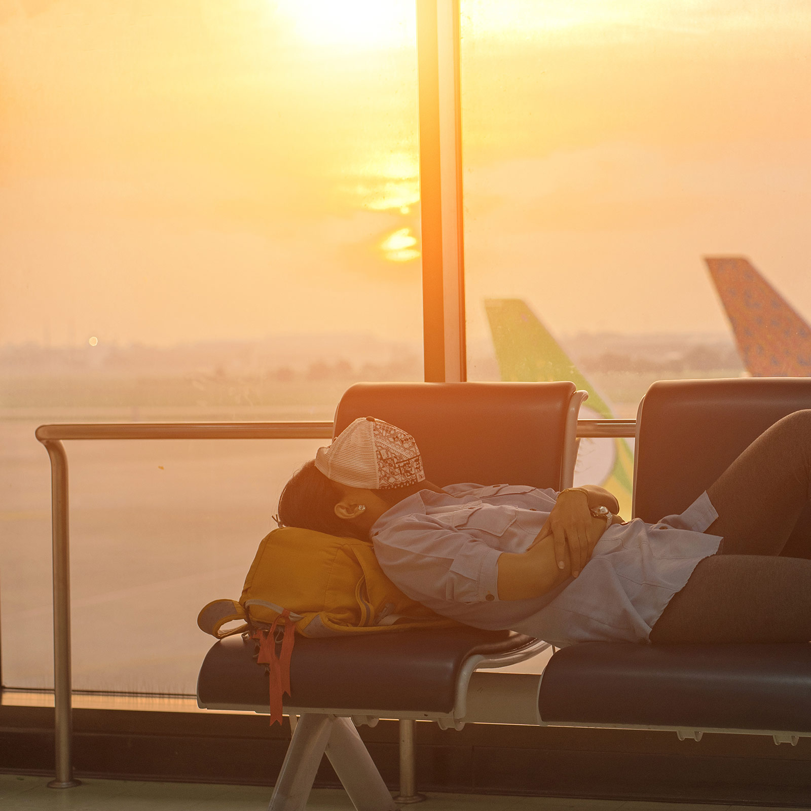 Lady sleeping in airport. How to sleep in airports