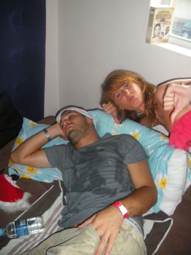 A guy sleeping and a girl spending Xmas on Bondi at Sunburnt festival. Xmas & NYE in Bondi, Sydney