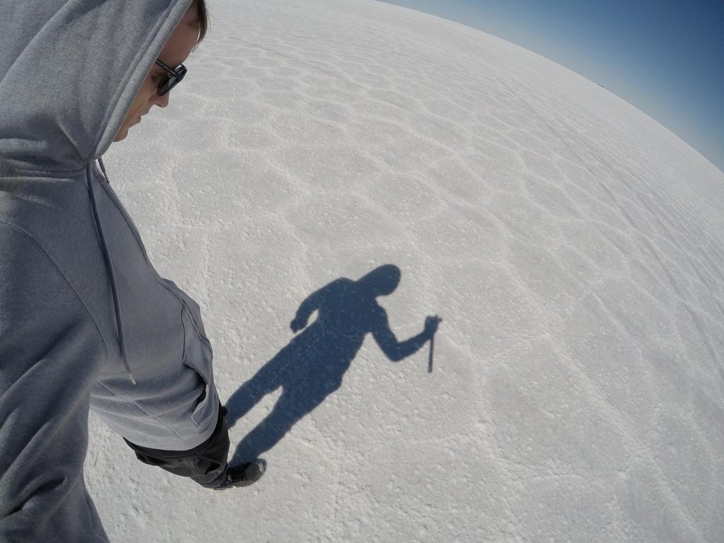 David Simpson watching his shadow in Uyuni Salt Flat, Bolivia. Atacama desert & Bolivian salt flats road trip & full guide