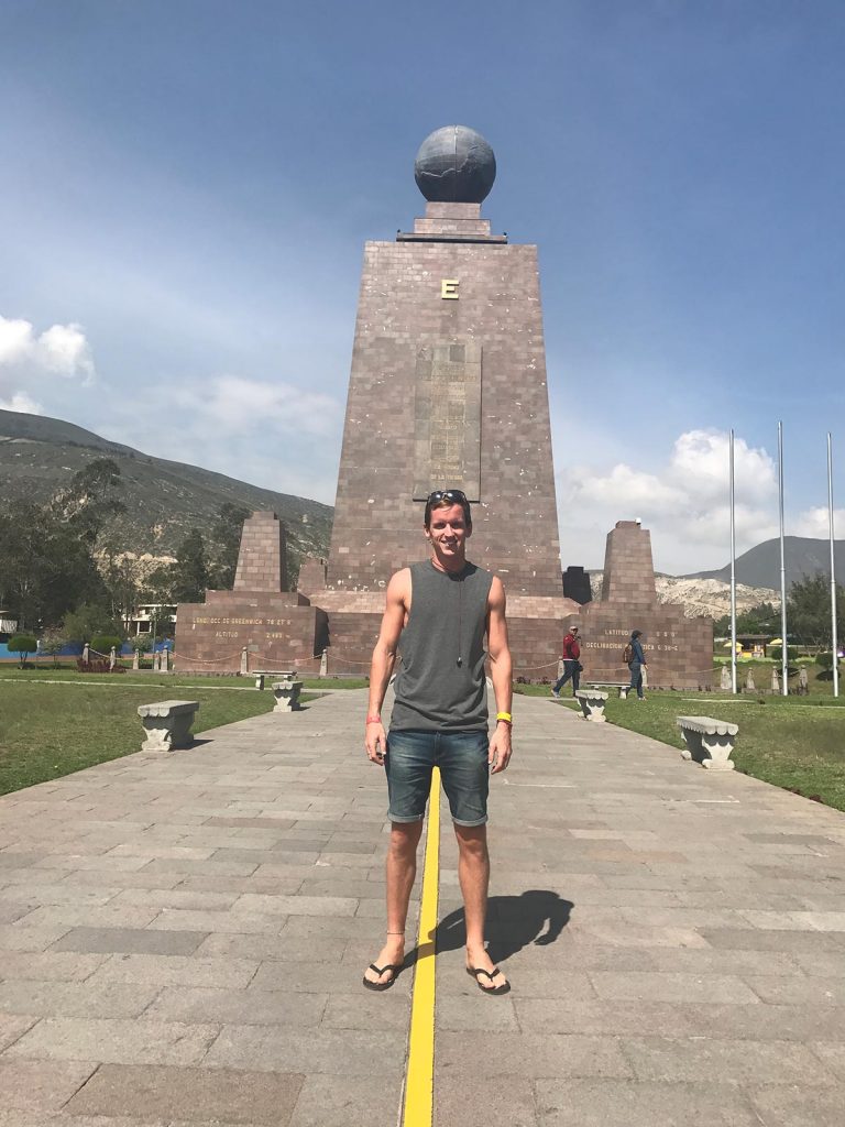 David Simpson standing on the equator marker line in Banôs, Ecuador. A Swing, The Equator & needing the Banôs in Banôs