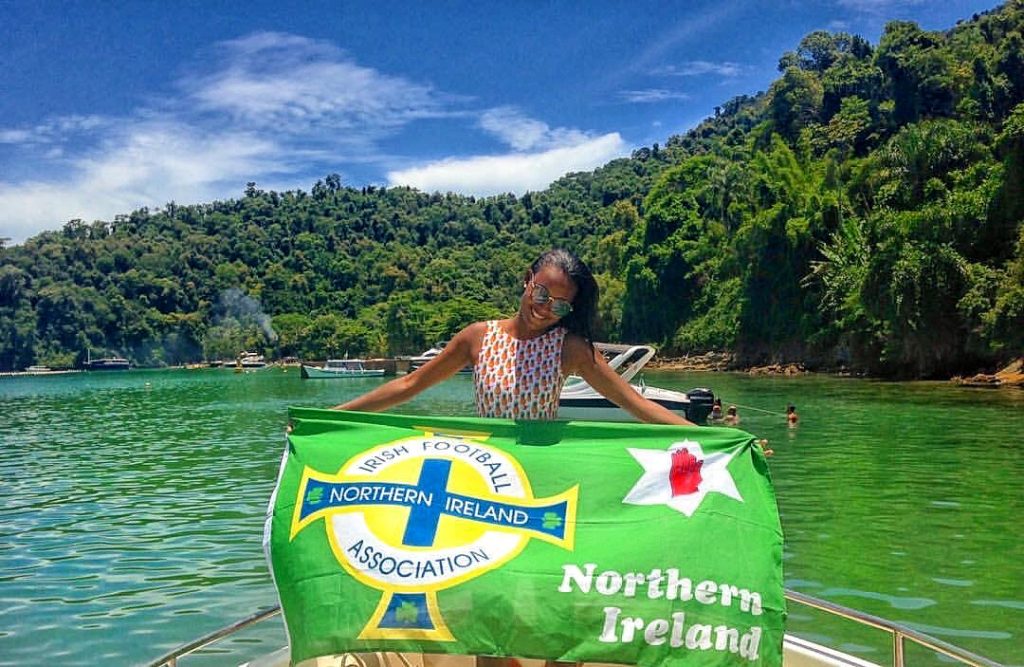Friend girl holding NI flag at speedboat tour in Ilha Grande, Brazil. Ilha Grande cures the hangover from hell