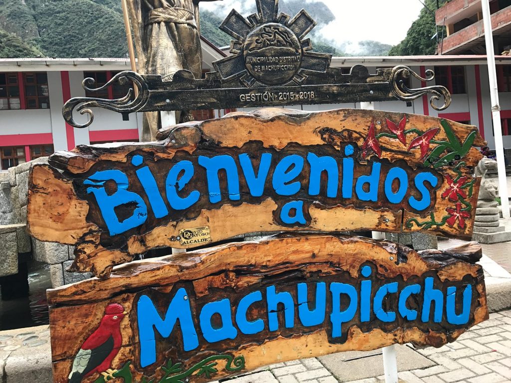 Bienvenidos a Machupicchu sign in the middle of the town in Machu Picchu, Peru. Checking out Machu Picchu and Full Guide