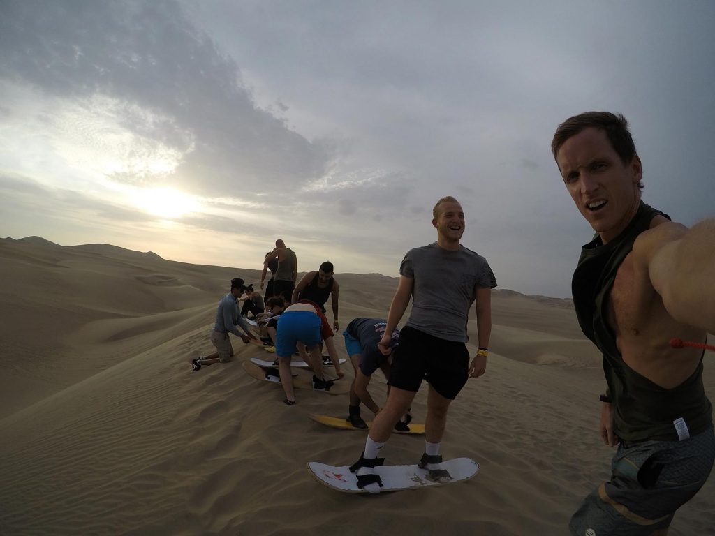 David Simpson and friends sand boarding on sand dune in Huacachina, Peru. Sand boarding in Huacachina & full guide