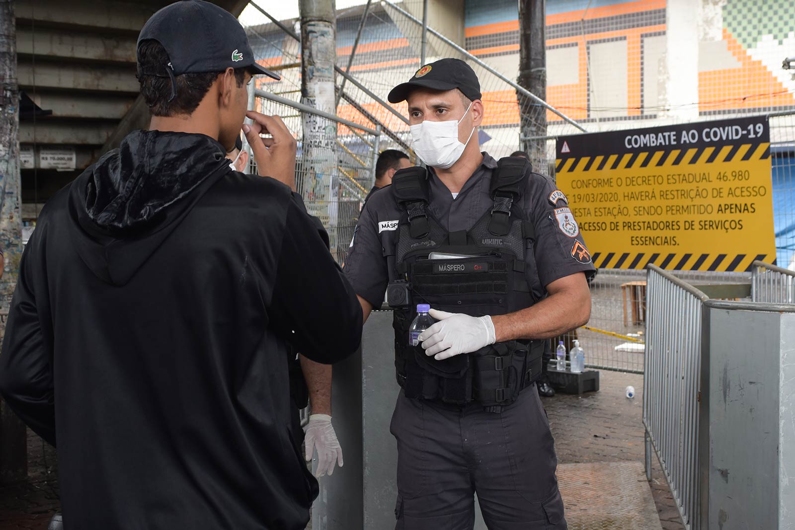 Policeman wearing mask talking to kid at border checkpoint. What for 2021…